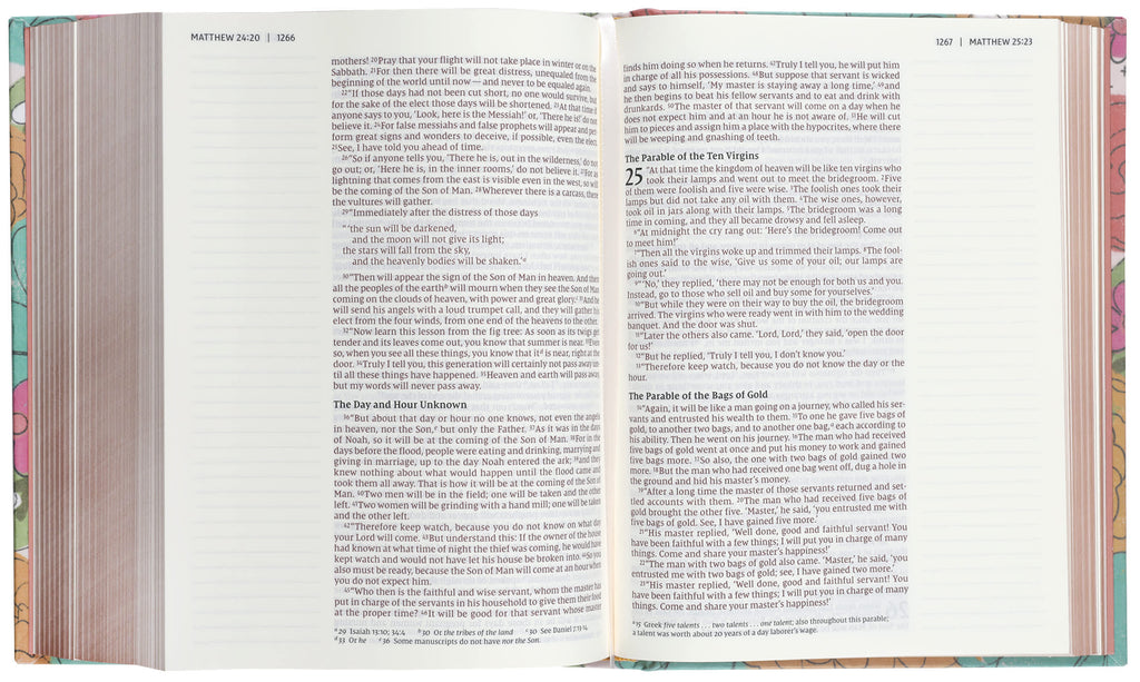 NIV Artisan Collection Bible with floral designs and wide margins on a desk