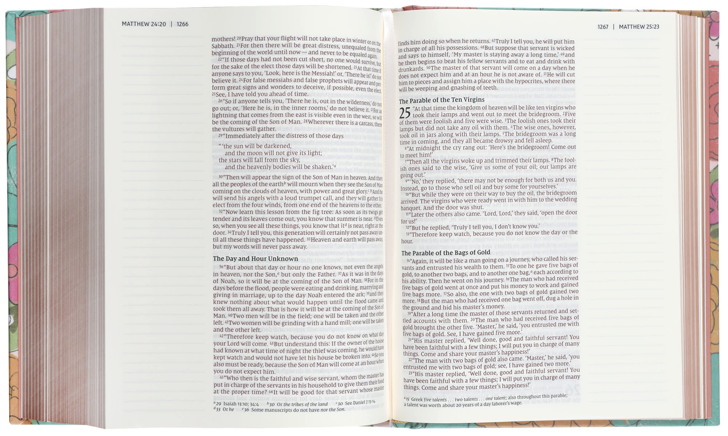 NIV Artisan Collection Bible with floral designs and wide margins on a desk