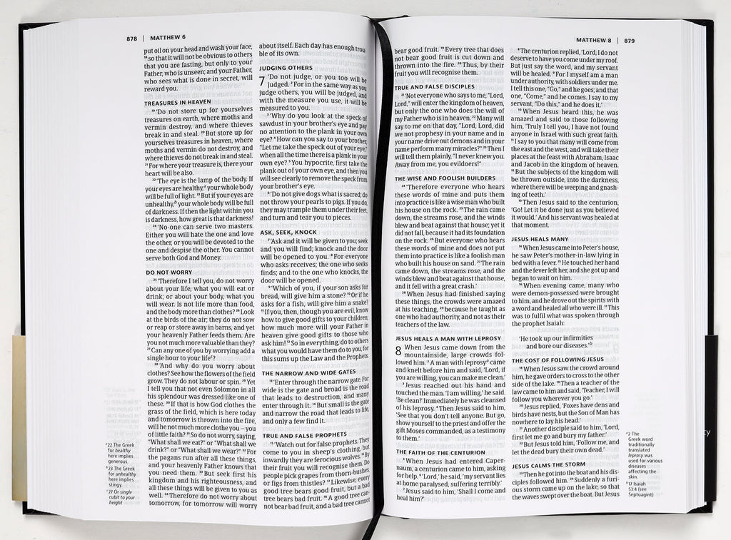 NIV Slimline Bible Black Anglicised Black Letter edition on a desk with reading glasses