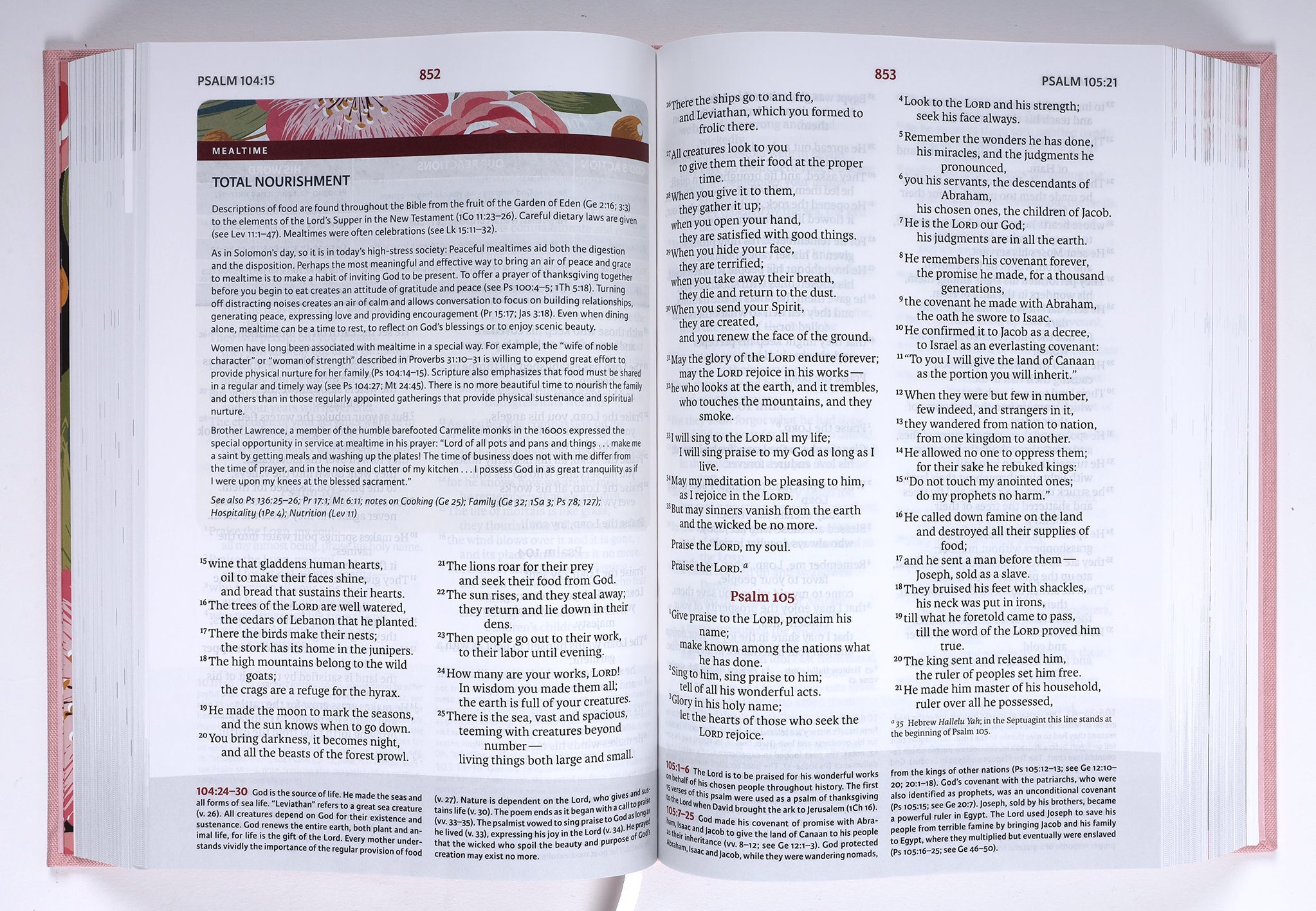 A woman holding the NIV Woman's Study Bible Pink Edition, reading and taking notes on its pages.