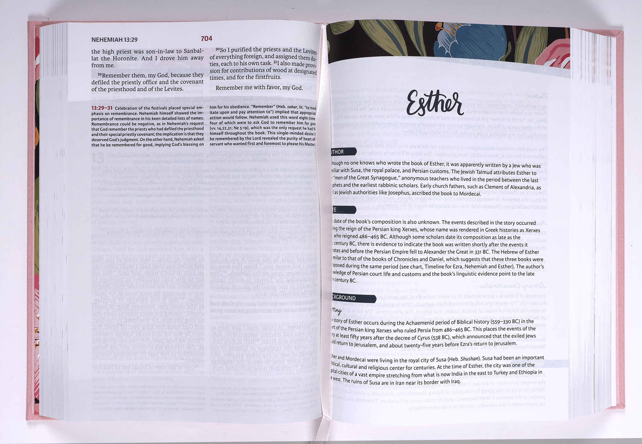 The NIV Woman's Study Bible Pink Edition on a desk, surrounded by other Christian study resources.