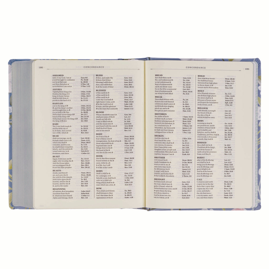 KJV journaling Bible with blue floral cover and black letter text on a bookshelf.